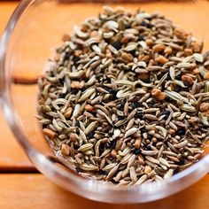 a glass bowl filled with seeds on top of a wooden table