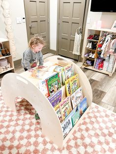 a young child is playing with a book stand