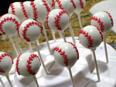 baseball cake pops on a white plate with red stitching