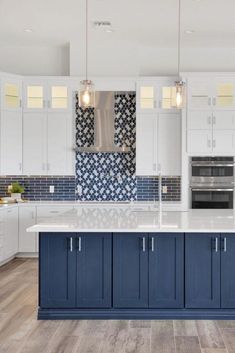 a large kitchen with white cabinets and blue counter tops, along with an island in the middle