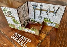 an open card with some gardening related items on the front and side, sitting on top of a wooden table