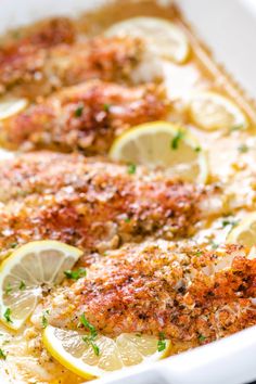 baked fish with lemons and parmesan in a white casserole dish