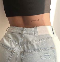 the back of a woman's stomach with her name tattooed on it