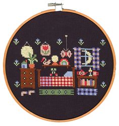 a cross stitched picture of a baby's crib and toys on a black background