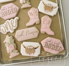 decorated cookies in the shape of cowgirl boots and cowboy boots on a cookie sheet