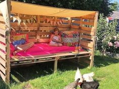 a woman sitting on a bed made out of pallets