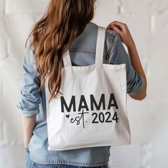 CUSTOM Tote. Celebrate the special "Mama" in your life with our "Mama Established [Year] Personalized Tote Bag"! This custom tote bag is the perfect gift for Mother's Day, birthdays, or any occasion that celebrates the amazing journey of motherhood. Personalize the tote with the year of becoming a mom or grandmother to create a truly unique and thoughtful gift. Available in 3 sizes to add both functionality and style, these custom-printed tote bags come with multiple handle colors to match your designs. Made with spun polyester, these bags feature double-stitched seams, cotton webbing straps, and nonwoven laminate lining for high-end durability. Your all-over print is created with dye sublimation for high-end visuals.  .: PRINTED ON BOTH SIDES!  .: Made with 100% polyester, a medium-weight Customizable Bags For Mother's Day, Personalized Everyday Use Bags For Mother's Day, White Large Capacity Bags For Mother's Day, White Large Capacity Bag For Mother's Day, White Bags With Large Capacity For Mother's Day, White Shoulder Bag With Letter Print For Mother's Day, White Canvas Shoulder Bag For Mother's Day, White Shoulder Bag For Travel On Mother's Day, Mother's Day Tote Bag