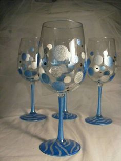 three wine glasses with blue and white designs on them