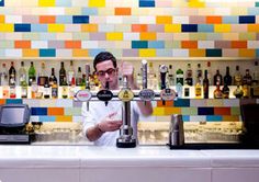 a man is making a drink at the bar