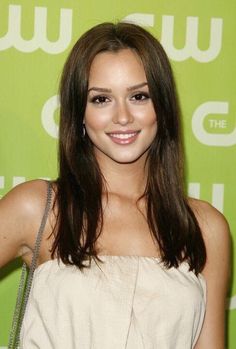 a beautiful young woman in a white dress posing for the camera with her hand on her hip