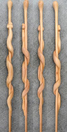 four wooden handmade canes lined up on the floor, one with twisted ends