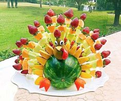 a turkey made out of fruit sitting on top of a white plate