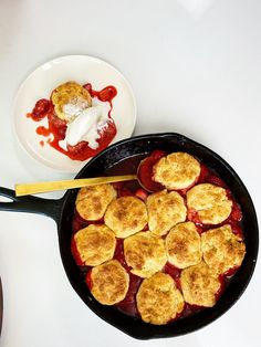 a skillet filled with food next to a bowl of sauce