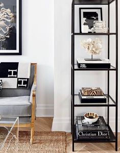 a black and white living room with bookshelf in the corner next to a chair