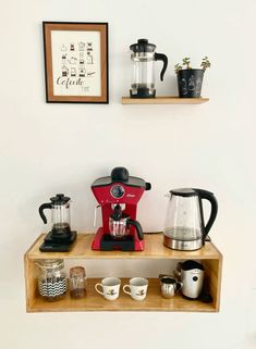 there is a coffee maker and cups on the shelf