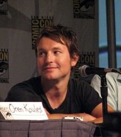 a man sitting at a table in front of a microphone