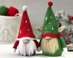 two crocheted gnomes sitting next to each other on top of a table