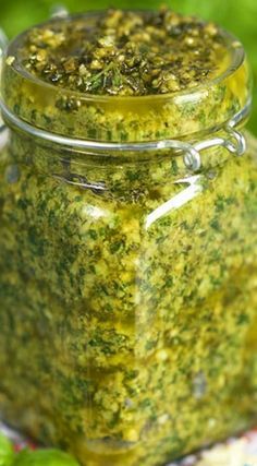 a glass jar filled with green pesto