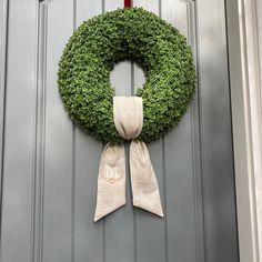 a green wreath hanging on the front door