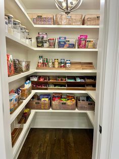 an organized pantry with white shelving and lots of food in baskets on the shelves