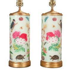 two lamps with flowers and birds on them are next to each other, one is gold