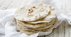 a stack of tortillas sitting on top of a wooden table