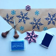 some crafting supplies are laid out on a table with blue and pink snowflakes