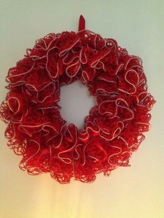 a red yarn wreath hanging on the wall