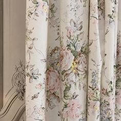 a curtain with flowers on it hanging in front of a window