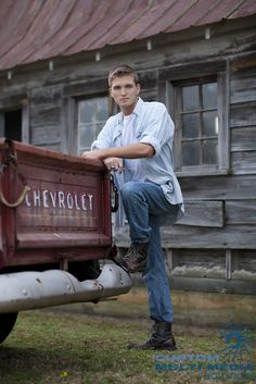 a man leaning on the back of a red truck