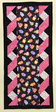 a black and pink quilt with hearts on it's side, in the center