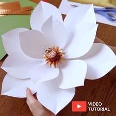 the paper flower is being made by someone using scissors and other crafting supplies to make it