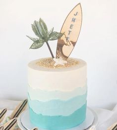 there is a cake with a surfboard on top and palm trees in the middle