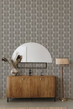 a large mirror sitting on top of a wooden dresser next to a wall mounted clock