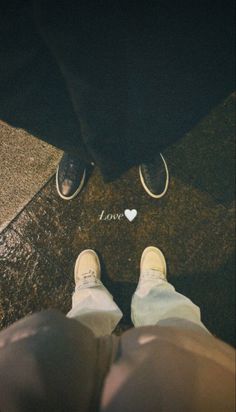 two people standing next to each other with their feet on the ground