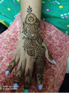 a woman's hand with henna tattoos on it