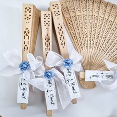 three wooden fans with ribbons and tags on them