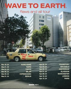 a yellow car is parked on the street in front of tall buildings with red lettering that reads wave to earth