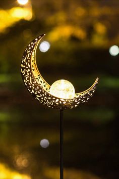 a lamp that is sitting on top of a stand with a moon in the middle