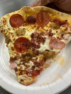 a slice of pepperoni pizza on a paper plate