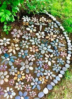 a circle made out of stones in the ground next to some trees and grass with green leaves around it