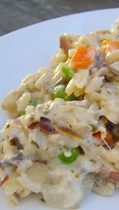 a white plate topped with chicken and rice casserole covered in veggies