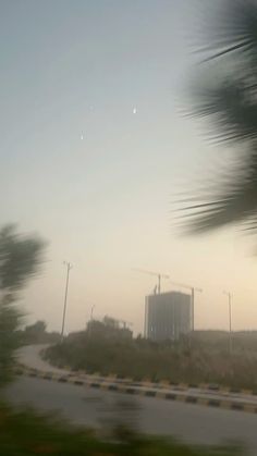 a blurry photo of an empty road with trees and buildings in the back ground