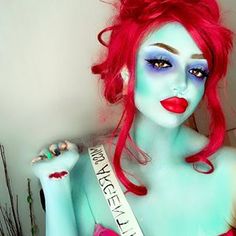 a woman with red hair and blue makeup