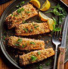 baked fish on a plate with lemons and parsley