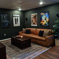 a living room filled with furniture and posters on the wall