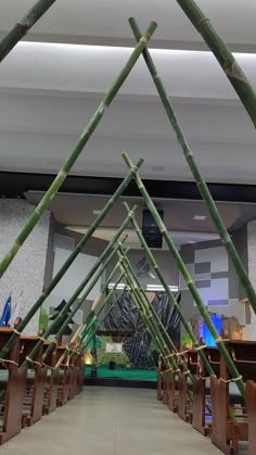 the inside of a building with wooden tables and benches lined up against each other in front of bamboo poles