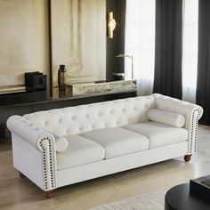 a white couch sitting in front of a mirror