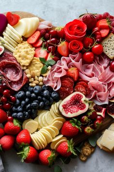 a heart shaped platter filled with fruit and cheese