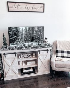 a christmas scene is displayed in the corner of a living room with a tv and chair